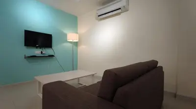 a living room with a couch and a table and a tv at Marina Island Lumut HomeHotel in Lumut