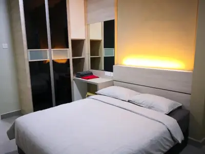 a bedroom with a large white bed with a night stand at CAMERON TROPICA HOMESTAY in Cameron Highlands