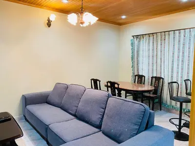 a living room with a blue couch and a table at 100 Oastel coLiving in Tanah Rata