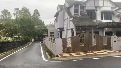 a house with a gate on the side of a road at 100 Oastel coLiving in Tanah Rata