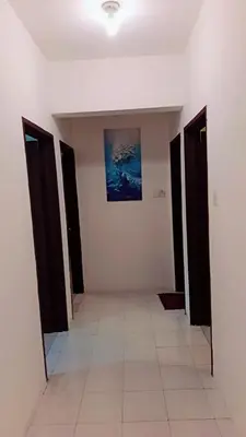 a hallway with black doors and a painting on the wall at Lumut Valley in Lumut