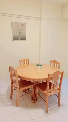 a wooden table with four chairs around it at Lumut Valley in Lumut