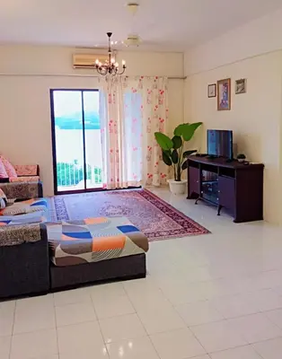a bedroom with a bed and a desk and a window at Lumut Valley in Lumut