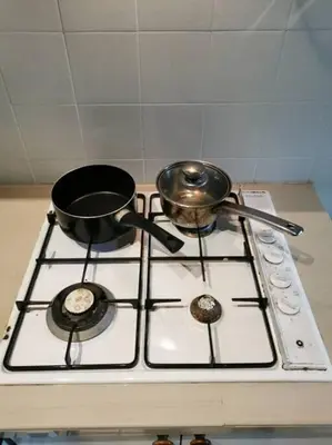 a stove top with two pots and pans on it at Cozy NEAR-BEACH Apartment ~The Napping House \u6d77\u6ee8\u516c\u5bd3~ in Batu Ferringhi