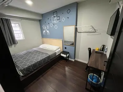 a bedroom with a bed and a table and a mirror at OU INN Cameron Highlands ,Ferm Nyonya Restaurant in Tanah Rata