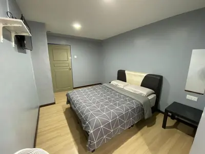 a small bedroom with a bed and a table at OU INN Cameron Highlands ,Ferm Nyonya Restaurant in Tanah Rata