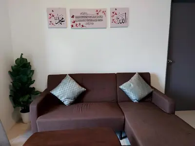 a brown couch with two pillows in a living room at EMERALD MUSLIM HOMESTAY CAMERON HIGHLANDS in Cameron Highlands