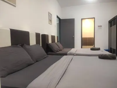 a bedroom with two beds and a door to a room at EMERALD MUSLIM HOMESTAY CAMERON HIGHLANDS in Cameron Highlands