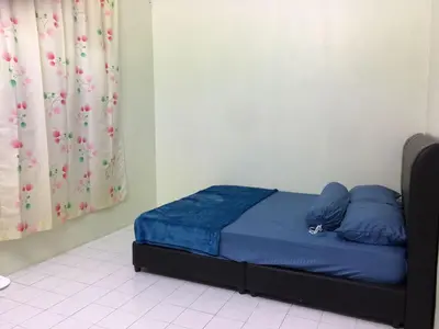 a bed with blue sheets and blue pillows in a room at Taiping Desa Jana Home Stay in Kamunting