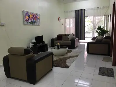a living room with two couches and a tv at Taiping Desa Jana Home Stay in Kamunting