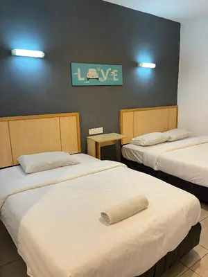 a hotel room with two beds with a towel on them at Fresh Hotel Falim in Ipoh