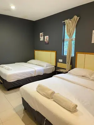a bedroom with two beds and a window at Fresh Hotel Falim in Ipoh