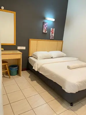 a bedroom with two beds and a desk and a mirror at Fresh Hotel Falim in Ipoh