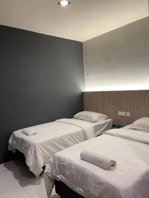 a room with three beds with white sheets at Fresh Hotel Falim in Ipoh