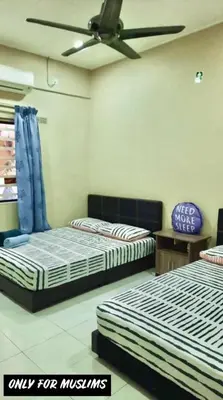 a room with two beds and a ceiling fan at Kinaz homestay in Ipoh