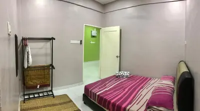a bedroom with a purple bed and a mirror at Kinaz homestay in Ipoh