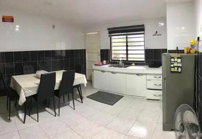 a kitchen with a table and chairs and a kitchen with a sink at Kinaz homestay in Ipoh