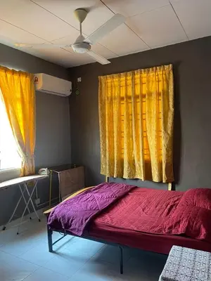 a bed in a room with yellow and purple curtains at Aqil Homestay Lunas Kulim for Mslim only in Lunas