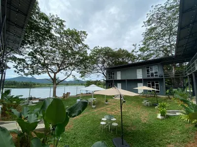a building with tables and umbrellas next to a body of water at 1108 Carebin Slim River in Slim River