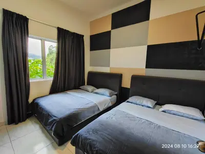 a bedroom with two beds and a window at Cameron Homestay in Tanah Rata