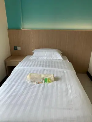 a bed with a bottle and a towel on it at M Quality Hotel in Gua Musang