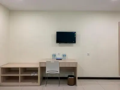 a desk with a television on a white wall at M Quality Hotel in Gua Musang