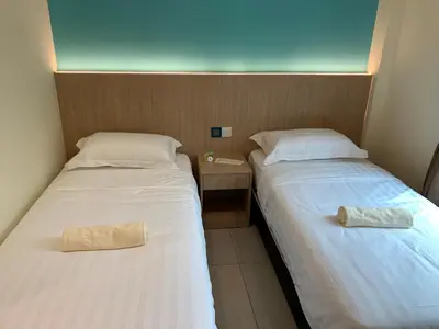 two beds sitting next to each other in a room at M Quality Hotel in Gua Musang