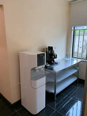 a kitchen with a counter and a table with a microwave at M Quality Hotel in Gua Musang