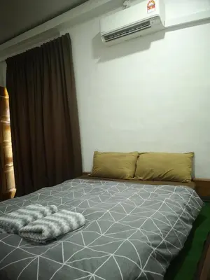 a bed with a blanket on it in a bedroom at Denai Senja in Kuala Selangor