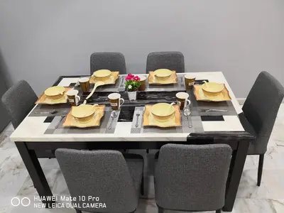 a dining room table with chairs and a table set with yellow napkins at TB HOMESTAY Tasek klebang(taman bertuah) 10pax wifi in Chemor