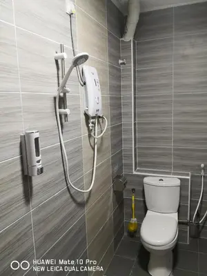 a bathroom with a shower and a toilet in a room at TB HOMESTAY Tasek klebang(taman bertuah) 10pax wifi in Chemor
