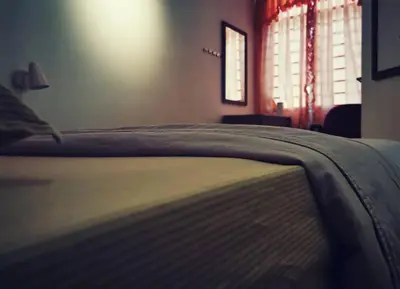 a close up of a bed in a bedroom at Cozy NEAR-BEACH Apartment - LazyCats' Den in Batu Ferringhi