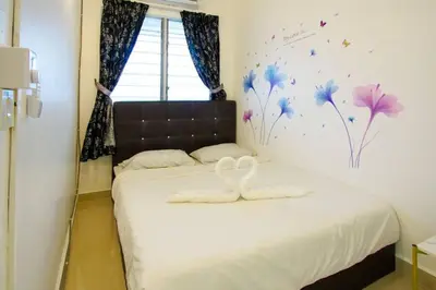 a bedroom with a bed with two white towels on it at Palm Court in Tanjong Tokong