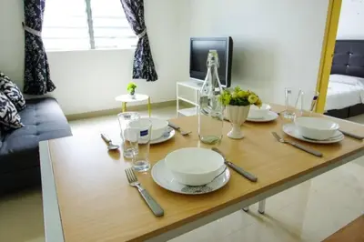 a table with plates and glasses on it in a living room at Palm Court in Tanjong Tokong