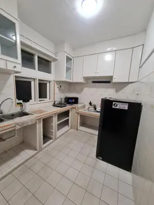a kitchen with white cabinets and a black refrigerator at JJ Home @ Jalan Burmah, Georgetown in George Town