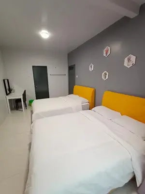 two beds in a room with white and yellow at Cameron Emerald Avenue Clover @ Brinchang in Brinchang