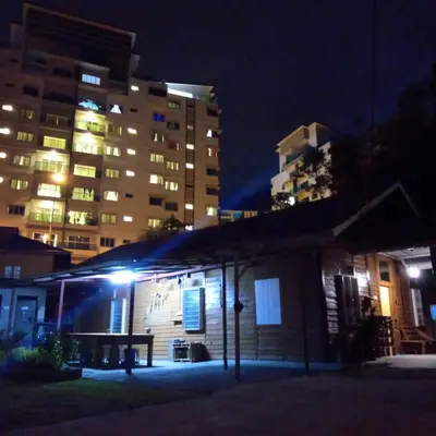 a building with a bench in front of a building at night at The Rustique Guest House in Tanah Rata