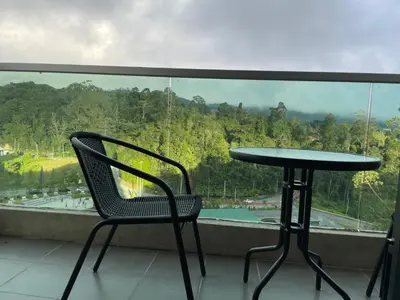 a table and chair on a balcony with a view at Paradise Penthouse 5 bedrooms 5 bathrooms in Tanah Rata