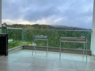 a balcony with two chairs and a view of a mountain at Paradise Penthouse 5 bedrooms 5 bathrooms in Tanah Rata
