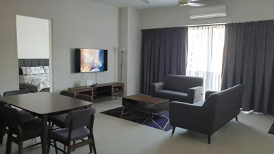 a living room with a table and chairs and a bedroom at TESS - By The Sea, Batu Ferringhi Penang in Batu Ferringhi