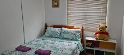 a teddy bear sitting on a bed in a bedroom at Citra Cottage Homestay in Sungai Petani