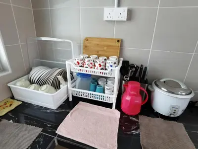 a bathroom with a toilet and a shelf with cups at My Homestay N43 (14 pax) @ Golden Hills Night Market in Tanah Rata