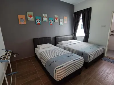two beds in a room with pictures on the wall at My Homestay N43 (14 pax) @ Golden Hills Night Market in Tanah Rata