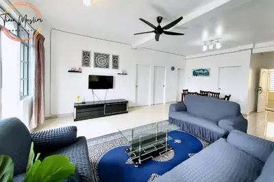 a living room with blue couches and a tv at Tiara Homestay 2 with 3 Bedroom, Unlimited Wifi - Brinchang in Brinchang