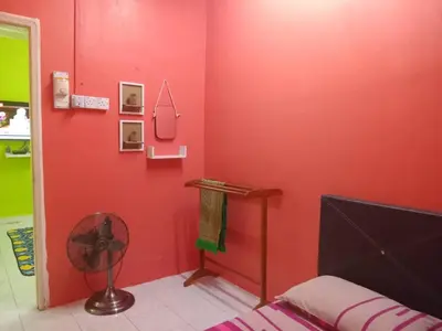 a red room with a fan and a red wall at Irfans HomestayDouble storey in Seri Manjung