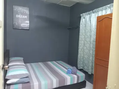 a small bedroom with a bed and a window at Irfans HomestayDouble storey in Seri Manjung
