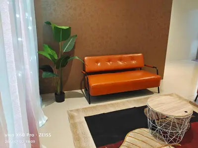 an orange leather chair sitting in a living room at PavilionVillie Ipoh in Kampong Sengat