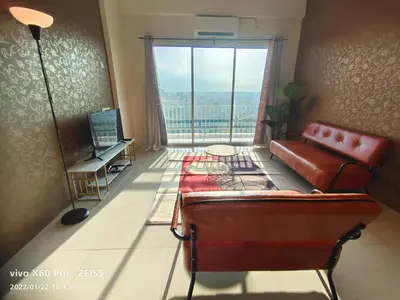 a living room with a couch and a large window at PavilionVillie Ipoh in Kampong Sengat