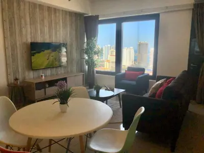 a living room with a couch and a table with chairs at Tropicana 218 Macalister Water Purifier By Blue Sky Holidays in George Town