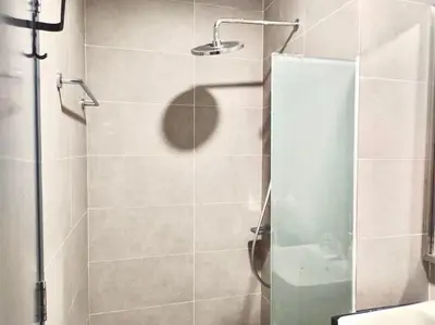 a shower with a glass door in a bathroom at Tropicana 218 Macalister Water Purifier By Blue Sky Holidays in George Town